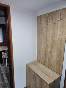 a room with a wooden cabinet with hooks on the wall at City View Apartment in Bijelo Polje