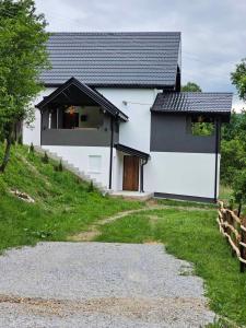 a white house with a black roof on a hill at City View Apartment in Bijelo Polje