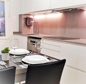 uma cozinha com dois pratos e copos de vinho numa mesa em El Manso, 150m Playa, Opción de Garaje em Gijón