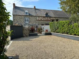 a house with a fence and a driveway at La maison du chêne 3 in Miniac-Morvan