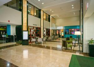 Holiday Inn Mayaguez & Tropical Casino, an IHG Hotel في ماياغيز: لوبي فيه كراسي وطاولات في مبنى