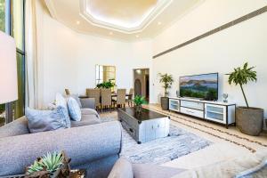 a living room with a couch and a tv at Palm Jumeirah Beachfront Private Villa with swimming pool in Dubai
