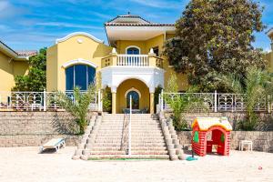 a house with a playground in front of it at Palm Jumeirah Beachfront Private Villa with swimming pool in Dubai
