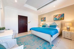 a bedroom with a bed with blue sheets and a blue rug at Palm Jumeirah Beachfront Private Villa with swimming pool in Dubai