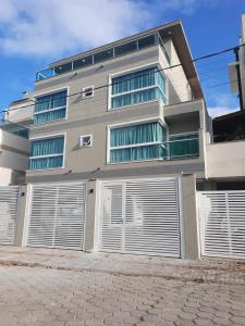 un edificio de apartamentos con puertas de garaje delante de él en Casa alto Padrão para temporada - cod 62, en Bombinhas