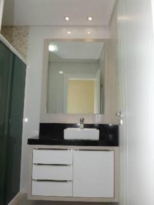y baño con lavabo y espejo. en Casa alto Padrão para temporada - cod 62, en Bombinhas