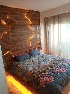 - une chambre avec un lit et une tête de lit en bois dans l'établissement Apparemment Rockisland, à Mohammedia