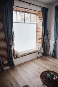 a living room with a large window and a wooden floor at Cozy Dreams: Deluxe 2-Zimmer-Apartment -Küche in Nürnberg
