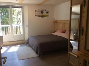 1 dormitorio con cama y ventana grande en Le Mas des Figuiers, en Donzère