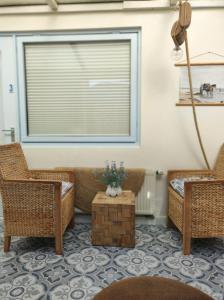 a living room with two chairs and a window at Zeelui in Egmond aan Zee