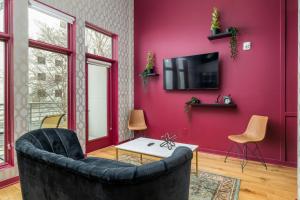 uma sala de estar com uma parede vermelha e uma televisão em Geranium Giant Close Proximity To Piedmont Park em Atlanta