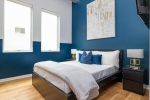 um quarto azul com uma cama e 2 janelas em Geranium Giant Close Proximity To Piedmont Park em Atlanta