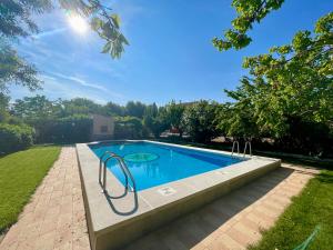una piscina en un patio con árboles y césped en CASA RURAL DOÑA LUCINDA, en Albacete