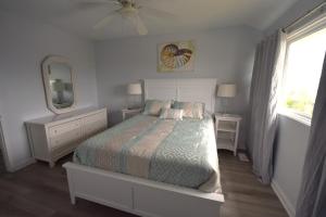 1 dormitorio con cama, espejo y ventana en Oceanfront vacation property - West en Emerald Isle