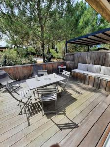 eine Terrasse mit einem Tisch, Stühlen und einem Sofa in der Unterkunft Appartement terrasse, quartier très prisé in Lège-Cap-Ferret