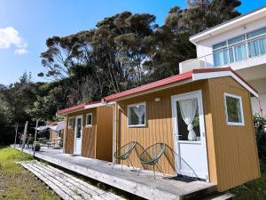 a tiny house on a dock next to a house at Haruru Falls Motel & Conference Centre in Paihia