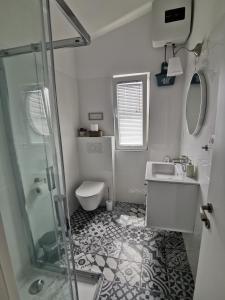 a bathroom with a shower and a sink and a toilet at Apartments by the sea Rogoznica - 4805 in Rogoznica