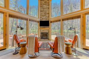 a living room with orange chairs and a fireplace at McKenzie River Retreat in Vida