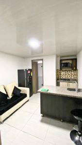 a living room with a couch and a kitchen at Apartahotel222 Pereira 403 in Pereira