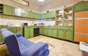 une cuisine avec des placards verts et un canapé bleu dans l'établissement Awesome Home In Trappeto With Wifi, à Trappeto