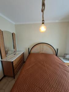 a bedroom with a bed and a mirror and a light at Casa Terreiro Da Lapa in Quintela