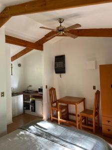 sala de estar con ventilador de techo, mesa y sillas en Rancho el Chilcal Cabañas con vista al rio, en San Alfonso