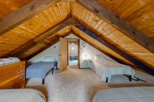 Cette chambre mansardée comprend 3 lits et un plafond en bois. dans l'établissement Lakes Region Leisure, à Belmont