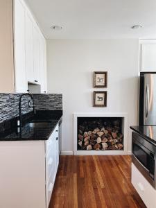 a kitchen with a fireplace with logs in it at Wm. Farmer and Sons in Hudson