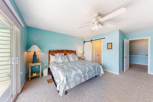 une chambre avec un lit et un ventilateur de plafond dans l'établissement Sandcastle #6F, à Dauphin Island 24 autres photos