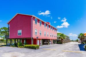 a red building in front of a parking lot at Sandcastle #6F in Dauphin Island