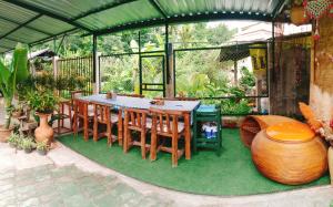 a patio with a table and chairs on grass at บ้านอังกาบ Aungkab homestay in Ban Muang Len