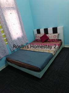 ein Schlafzimmer mit einem Bett mit Rishilords Homogenese darauf geschrieben in der Unterkunft Roslin's Homestay 2 in Kota Bharu