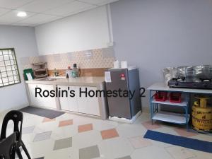 eine Küche mit einem Kühlschrank und einer Arbeitsplatte in der Unterkunft Roslin's Homestay 2 in Kota Bharu