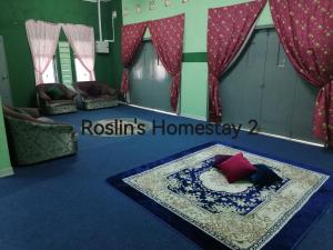 ein Zimmer mit einem Sofa und einem Tisch mit einem Teller in der Unterkunft Roslin's Homestay 2 in Kota Bharu