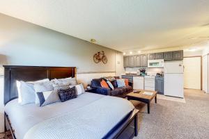 a bedroom with a large bed and a kitchen at Overlook Nook #241 in Granby