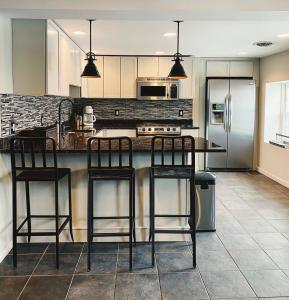 a kitchen with a counter with three bar stools at Wm. Farmer and Sons in Hudson