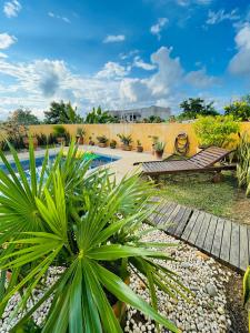 a garden with a pool and a wooden walkway at Villa Bonobo in Puerto Escondido