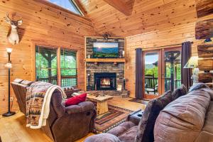 ein Wohnzimmer mit einem Kamin in einer Blockhütte in der Unterkunft Incredible Views! - Pet Friendly - Aska Adventure Area - Bearfoot Bungalow in Blue Ridge