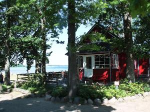 a red and white house in the trees at Cosy Apartment Ostsee in Zierow with Terrace in Zierow
