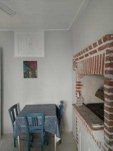einen Tisch und Stühle in einer Küche mit einem Steinofen in der Unterkunft Mimosa House Ayvalık in Ayvalık