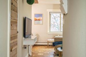 a living room with a television on a dresser and a window at Colorful downtown condo, 2 bedrooms, king bed in Seattle