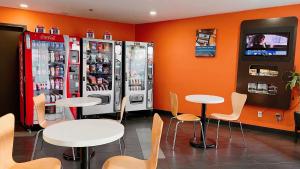 a restaurant with two soda machines and two tables at Motel 6-Regina, SK in Regina