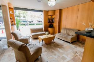 a living room with chairs and a couch and a table at Grand Hotel Loja in Loja