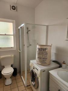 een badkamer met een wasmachine en een toilet bij Peaceful Getaway! in Sydney