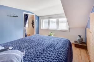 een slaapkamer met een blauw bed en een raam bij The Mandeville Rustic Chalet Lake Access + Jacuzzi in Mandeville