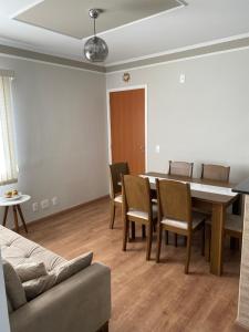 a living room with a dining room table and chairs at Apartamento do Renan in Espirito Santo Do Pinhal