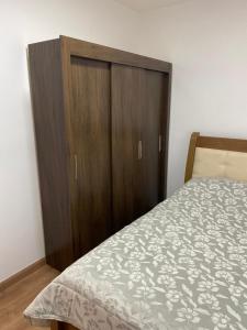 - une chambre avec un lit et une armoire en bois dans l'établissement Apartamento do Renan, à Espirito Santo Do Pinhal