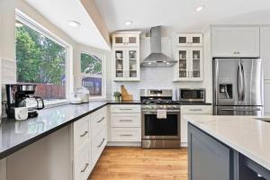 una cocina con armarios blancos y electrodomésticos de acero inoxidable en Eagle ID Getaway - 4 bed 3 bath - Fully renovated en Eagle