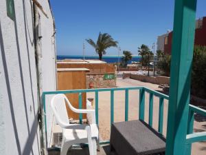 a white chair sitting on a balcony overlooking the beach at Lilly Rooms and Studio in Hurghada