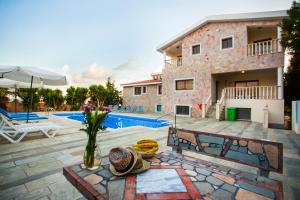 a house with a swimming pool and a patio at Villa Kapistris Dyo in Coral Bay